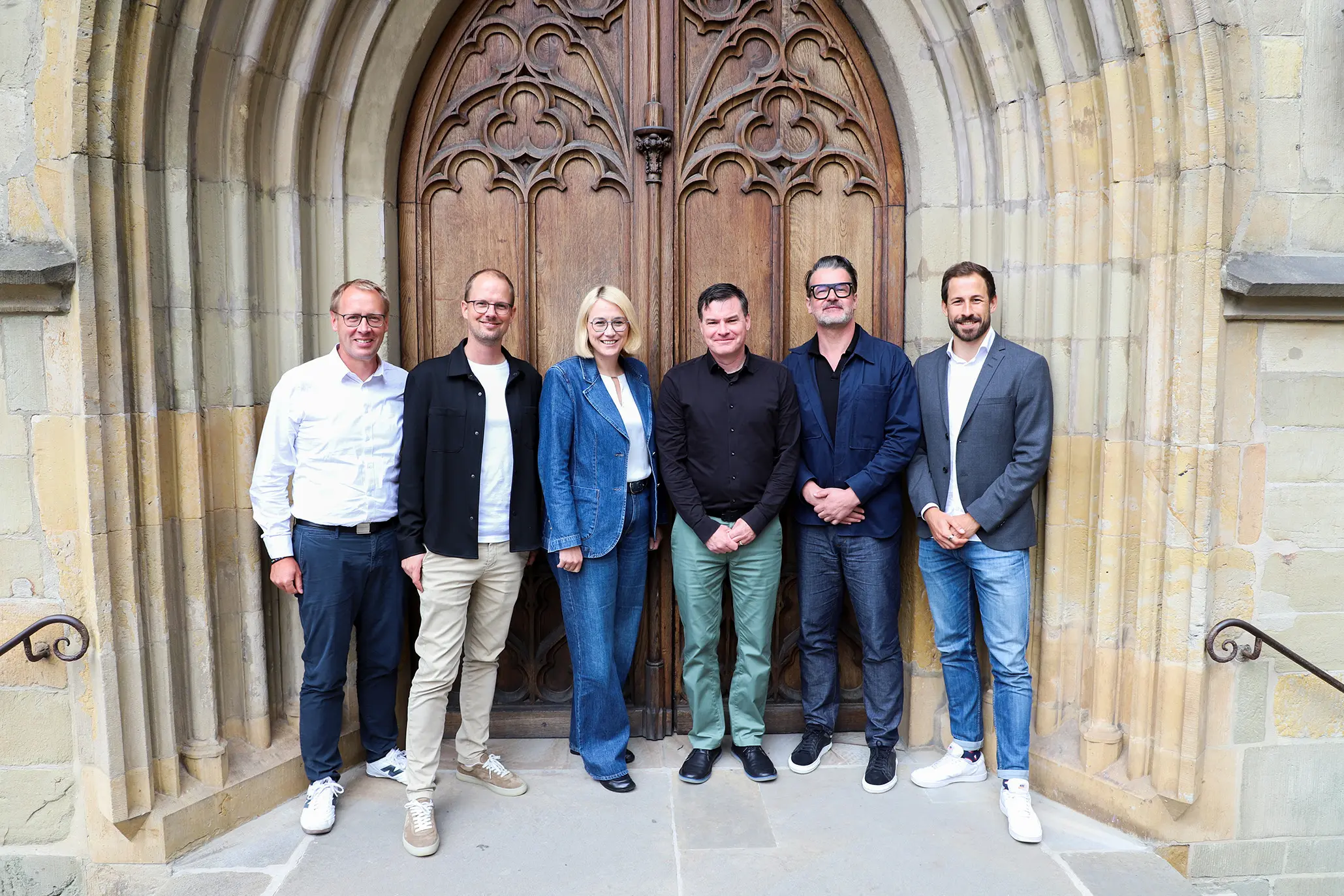Personen vor Holztür, Bremer Brücke Sanierung, Pressebild für Stadiongesellschaft.
